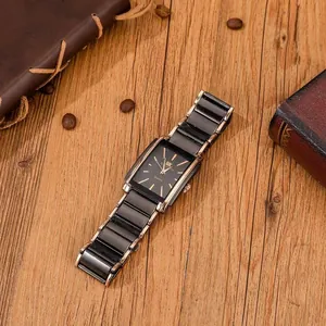 Detailed close-up of a square business quartz watch with rose gold accents on a wood desk