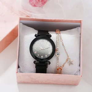 Close-up of women's quartz watch and rose gold star bracelet in a pink gift box