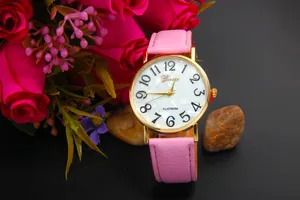 Detail of pink leather watch strap with gold casing and pearlescent floral dial