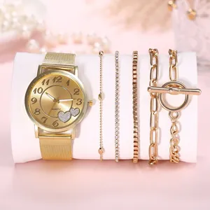 Gros plan d'une montre dorée en maille et de quatre bracelets assortis pour femme