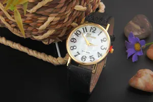Detailed view of the quartz watch with white mother of pearl dial and black leather strap