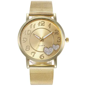 Détail d'une montre à quartz dorée avec motifs de cœurs et bracelet en maille