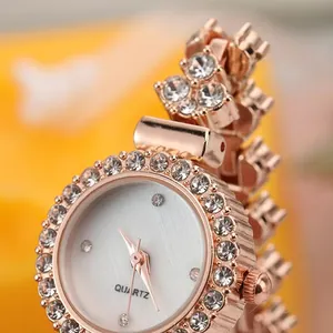 Dettaglio dell'orologio in oro rosa con strass scintillanti e quadrante al quarzo bianco