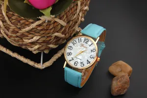 Close-up of Geneva light blue leather watch with golden case and pearl texture dial