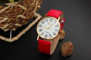 Close-up of Geneva watch with red leather strap and marble dial in gold case