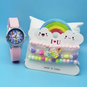 Close-up of pink rabbit quartz watch and beaded bracelets on decorative rainbow card