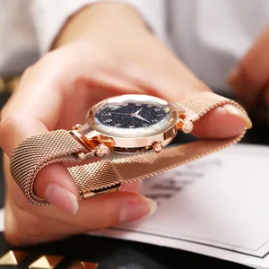 Détail du bracelet en maille or rose et cadran bleu étoilé avec verre facetté et chiffres