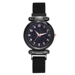 Détail du cadran ciel étoilé avec chiffres or rose et bracelet magnétique noir