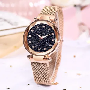 Detail of rose gold mesh watch with starry dial and faceted glass bezel on soft fabric