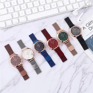 Vue à plat de montres à quartz avec bracelets magnétiques en maille sur fond de marbre