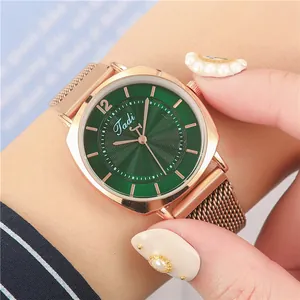 Détail de montre pour femme avec cadran vert et bracelet magnétique milanais en or rose
