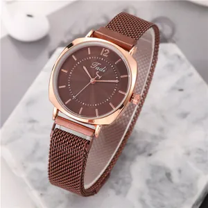 Détail du boîtier en or rose et du bracelet milanais brun sur marbre