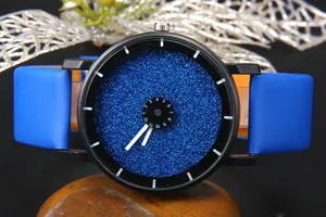 Vista dettagliata del quadrante blu glitterato con disco numerico su sfondo di sassi