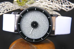 Dettaglio dell'orologio con quadrante glitter stellato e disco rotante su sasso