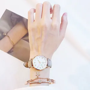 Gros plan détaillé d'une montre à quartz en or rose avec un bracelet à breloques étoile