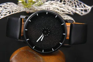 Dettaglio dell'orologio con quadrante nero opaco, disco rotante e cinturino in pelle