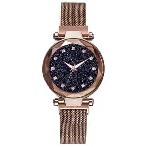 Close-up of starry sky dial with crystal markers and faceted glass on rose gold watch