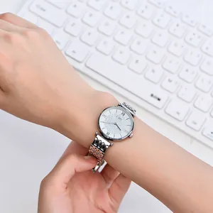 Close-up of a silver starry sky quartz watch with rhinestone dial on a white keyboard