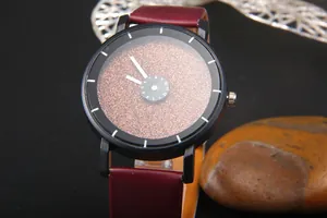 Dettaglio di un orologio al quarzo stellato con cinturino in pelle bordeaux e cassa nera