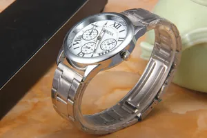 Macro detail of silver Geneva watch with Roman numerals and stainless steel mesh strap