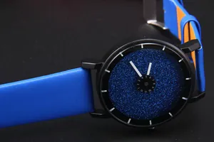 Dettaglio del quadrante cielo stellato blu con cassa nera e cinturino in pelle arancione