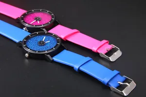 Dettaglio di orologi glitterati cielo stellato rosa e blu con quadrante minimalista e cinturini