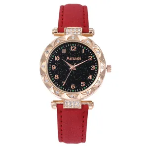 Dettaglio di orologio in oro rosa con quadrante stellato e cinturino rosso