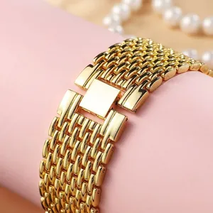 Close-up of luxury gold-plated multi-link watch strap with square buckle on pink display
