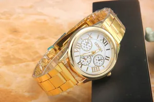 Close-up of golden Geneva watch with white Roman dial and protective film on band