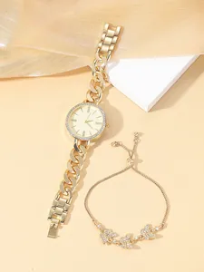 Elegant gold watch set with crystal bezel and butterfly bracelet on beige background
