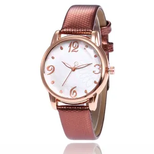 Close-up of rose gold watch with floral white dial and brown textured leather strap