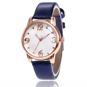 Detail of rose gold ladies watch with floral dial and dark blue textured leather strap