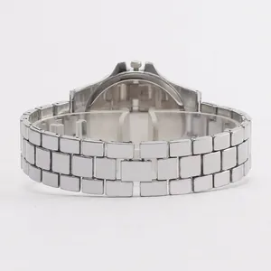 Close-up of the silver stainless steel three-row watch strap and case back on a stand