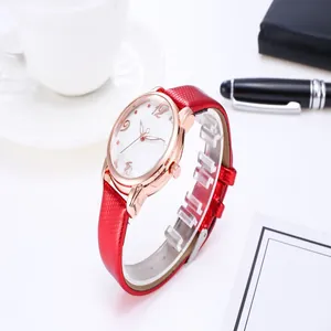Red snake-pattern leather watch strap and rose gold case detail in office setting