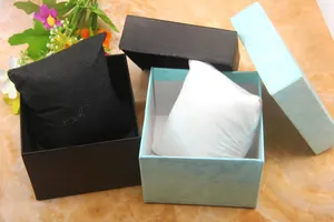 Close-up of textured square watch gift boxes in black and sky blue with pillows