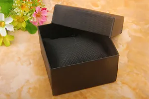 Macro detail of a black textured watch gift box with a soft cushion insert on marble