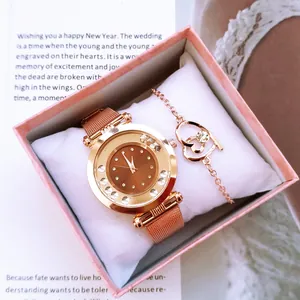 Coffret cadeau avec montre femme en or rose et bracelet cœur sur un coussin blanc