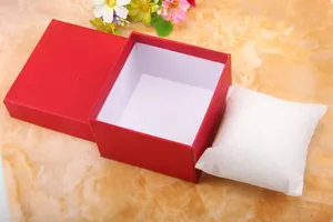 Macro shot of red textured paper gift box with white cushion for watches and bracelets