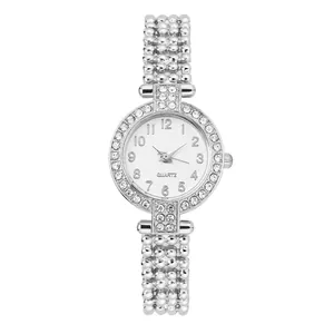 Detalle de reloj de cuarzo plateado con bisel de strass y pulsera de cadena fina