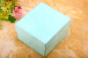 Tiffany blue gift box with marble texture and floral accents on a warm tabletop