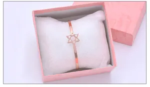 Nahaufnahme eines roségoldenen Sternarmbands in einer rosa Marmor-Geschenkbox