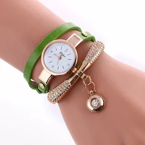 Detail of rose gold quartz watch with green embossed leather strap and crystal charms