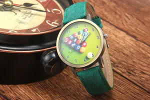 Macro view of vintage bronze billiard watch with green canvas strap and pool theme dial