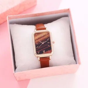 Λεπτομέρεια ορθογώνιου ρολογιού rose gold με δερμάτινο λουράκι σε ροζ κουτί δώρου