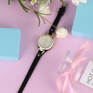 Gros plan d'une petite montre à quartz pour femme avec bracelet en cuir noir doré