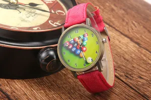 Detailed side view of vintage bronze billiards watch with green dial and red fabric strap