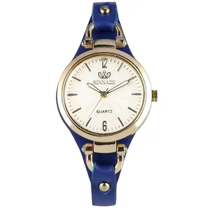 Détail de la montre à quartz RINNADY avec boîtier doré, bracelet en cuir bleu et clous