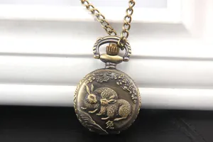Dettaglio di un orologio da taschino vintage in bronzo con rilievo di coniglio e fiori