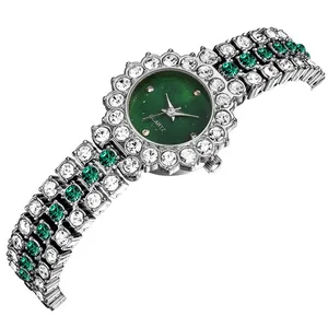 Dettaglio di un orologio argento con quadrante verde scuro e strass color smeraldo lucidi