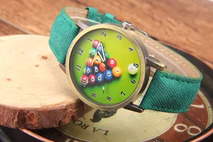Detail view of vintage bronze quartz watch with green billiards theme dial and canvas strap